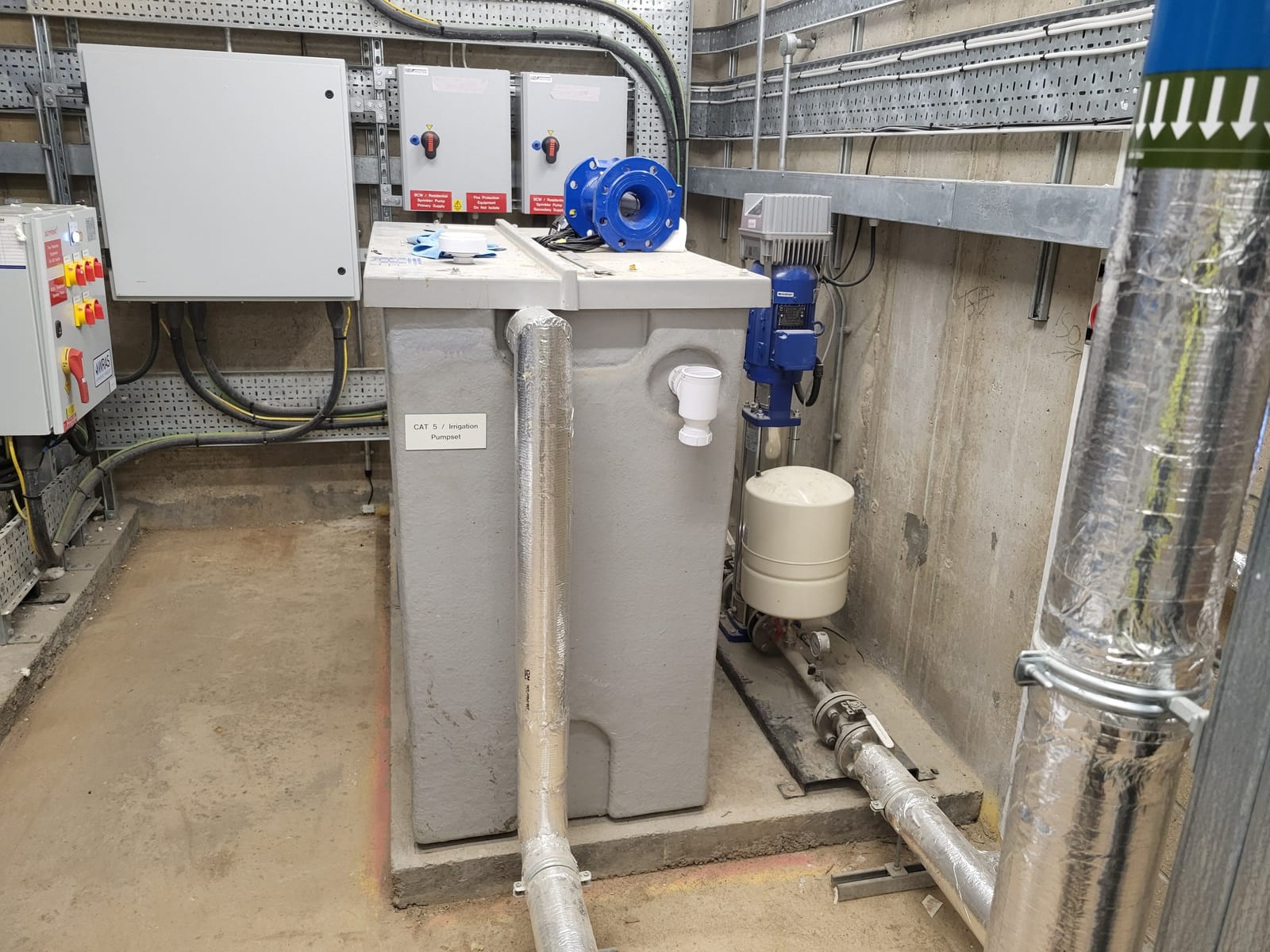 Irrigation storage tank, pump and associated pipework in the plant room at Bargate Quarter.