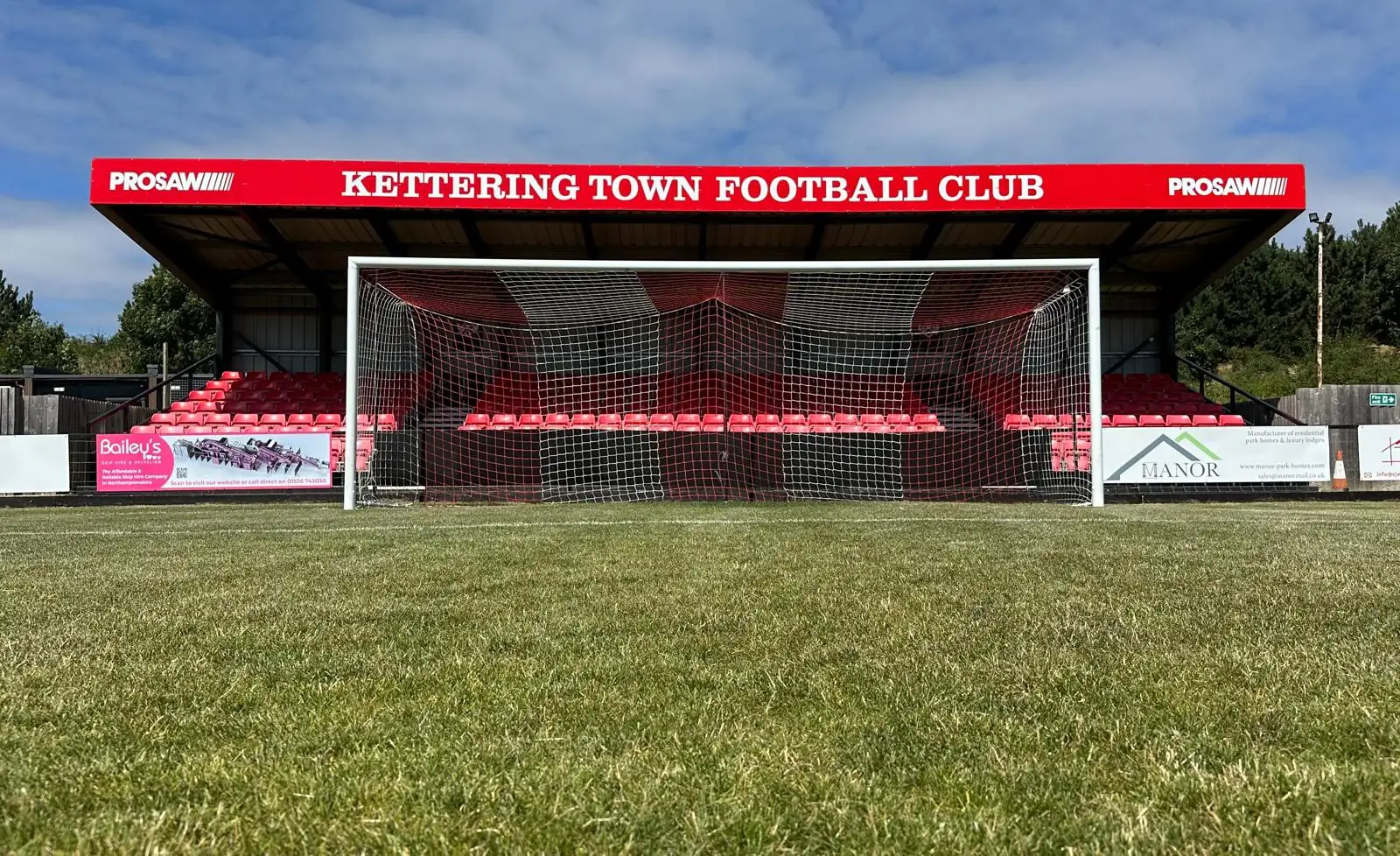 Football goal and grandstand viewed from the pitch
